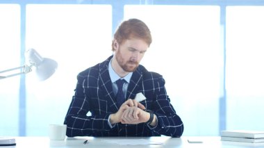 Ofiste iş yerinde smartwatch kullanan adam