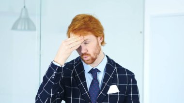 Baş ağrısı, üzgün gergin genç Redhead iş adamı