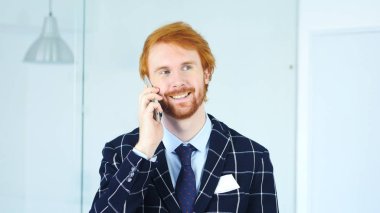 Pozitif adam Smartphone ofisinde otururken, konuşurken