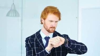 Kızıl saçlı işadamı smartwatch ofiste iş yerinde kullanarak