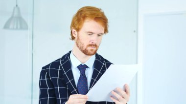 Office Douments iş yerinde okuma, adamla kırmızı saç sakal