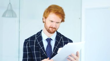 Adam okuma Office Douments iş, kırmızı saçlar