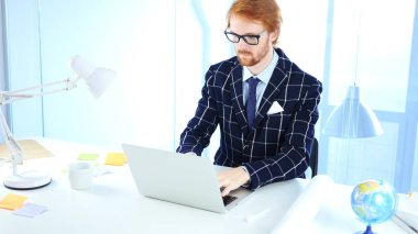 Kızıl saçlı işadamı yaratıcı Freelancer tasarımcı laptop ofis, çalışma