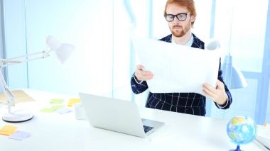 Kızıl saçlı mimari mühendis açılış Blueprint, Freelancer tasarımcısına