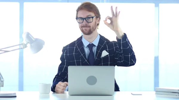 Redhead affärsman med tillfredsställelse gest på jobbet, okej — Stockfoto