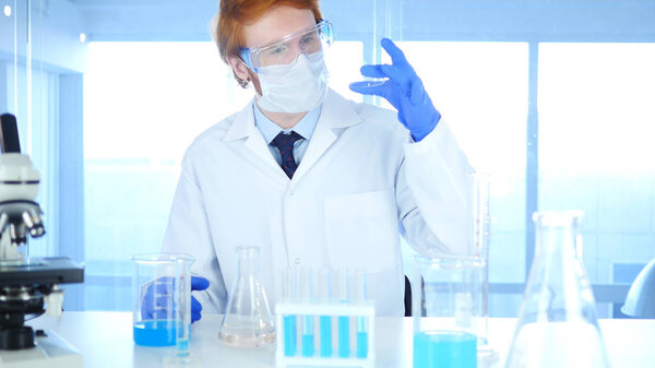 Medical Scientist Studying Reaction in Watch Glass in Laboratory