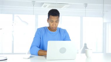 Laptop ofiste çalışan Afro-Amerikan adam