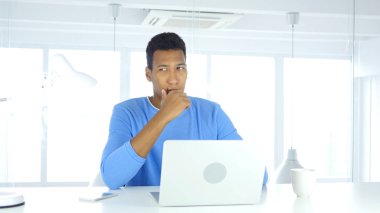 Düşünme ve dizüstü bilgisayarda çalışma Afro-Amerikan adam