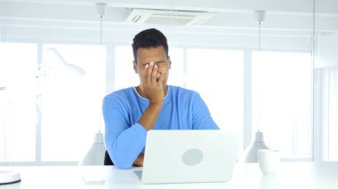 İş yerinde oturan yorgun Afro-Amerikan adam