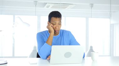 İş yerinde oturan uyuyan genç Afro-Amerikan adam