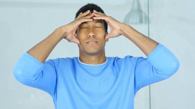 Baş ağrısı, üzgün gergin genç Afro-Amerikan adam başını tutan