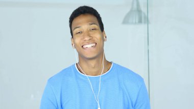 Kulak kulaklık ile pozitif gülümseyen Afro-Amerikan adam