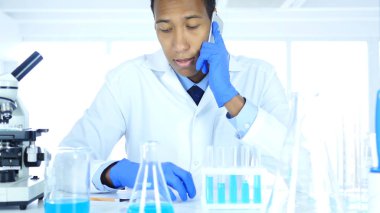 Laboratuvar telefonda konuşurken Afro-Amerikan bilim adamı