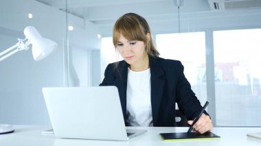 Genç kadın Tasarımcısı çalışma ile grafik tablet üstünde Laptop