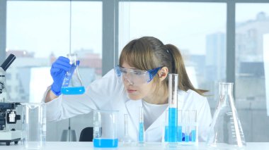 Laboratuvar şişesi reaksiyonu sonuçlarını bakarak kadın bilim adamı
