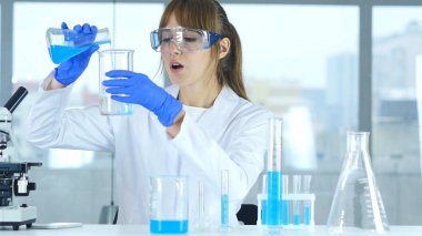 Laboratuvar kimyasal çözüm Test tüpü içinde dökme, çalışan kadın bilim adamı