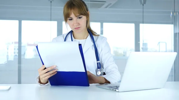 Ung kvinna läkare läsa medicinska rapporter av Patient, diagnos — Stockfoto