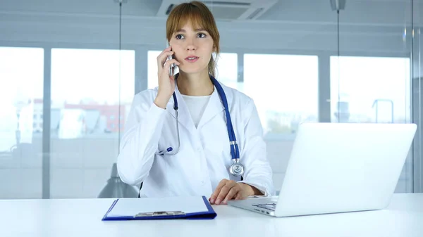Ung kvinna läkare prata telefon på sjukhus — Stockfoto