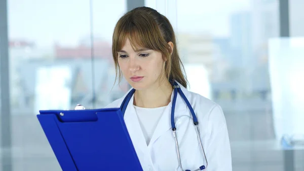 Close Up of Female Doctor Reading Relatórios Médicos — Fotografia de Stock