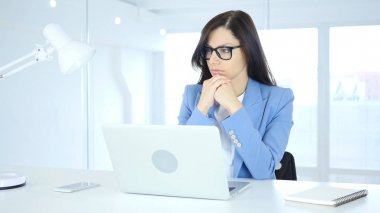 Düşünme ve dizüstü bilgisayarda çalışan dalgın genç iş kadını