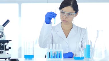 Araştırma bilim adamı, Doktor tüp laboratuvar mavi çözümde bakarak