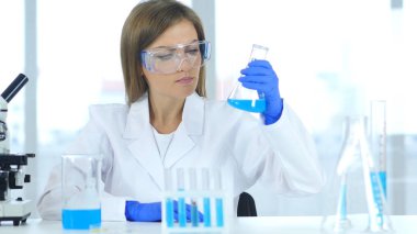 Laboratuvar şişesi reaksiyonu sonuçlarını bakarak kadın bilim adamı