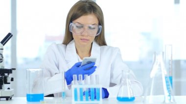 Kadın bilim adamı laboratuvarda Smartphone kullanarak