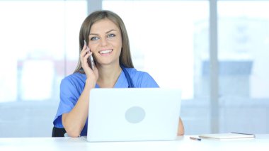 Genç erkek doktor hastanede telefonda konuşuyor