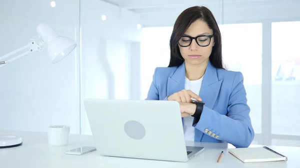 Mujer usando Smartwatch en el trabajo en la oficina — Foto de Stock