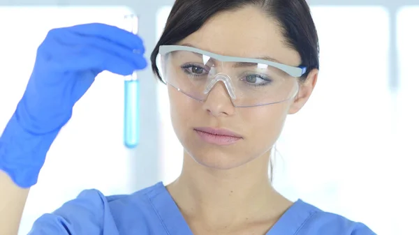 Ερευνητικός επιστήμονας που βλέπουν μπλε λύση σε δοκιμαστικό σωλήνα στο εργαστήριο — Φωτογραφία Αρχείου