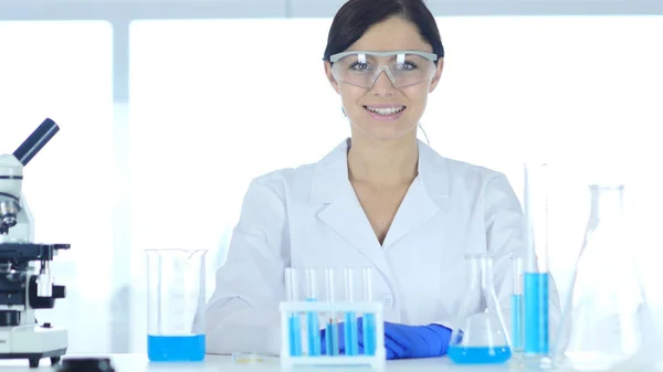 카메라를 보고 하는 실험실에 앉아 웃는 성공적인 여성 과학자 — 스톡 사진