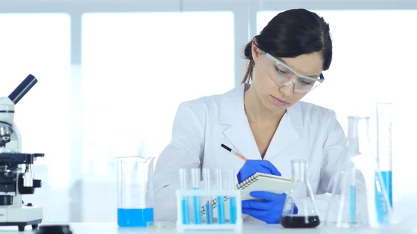 Scientist Writing Details, Result of Research in Laboratory