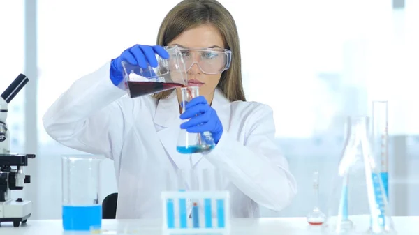 실험실, 테스트 튜브에 화학 솔루션을 붓는에서 일 하는 여성 과학자 — 스톡 사진