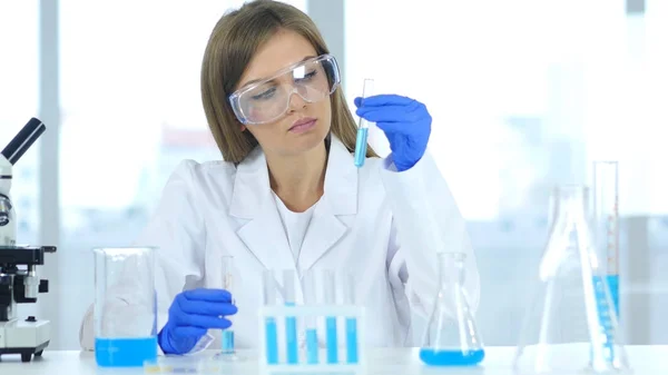 Tubo de ensayo de retención de científicos femeninos con solución azul en laboratorio — Foto de Stock