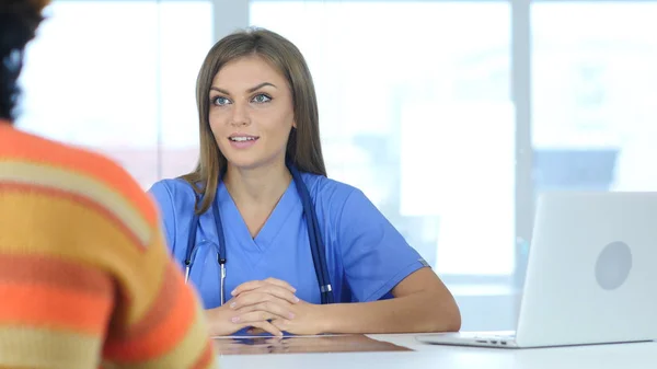 Médica positiva conversando com paciente, discutindo sobre cuidados de saúde — Fotografia de Stock