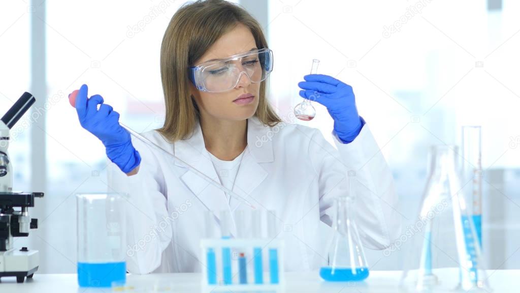 Female Research Scientist Doing Chemical Reaction in Laboratory