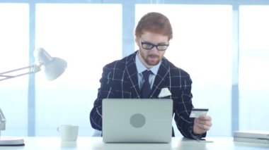 Kızıl saçlı işadamı Online alışveriş, kredi kartı ile ödeme için heyecanlı