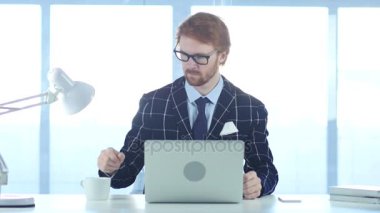 Rahatlatıcı ve iş yerinde kahve içme Kızıl saçlı işadamı