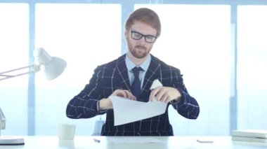 Öfkeli kızıl saçlı adam yırtılma gazetelerde ofis, iş başarısız