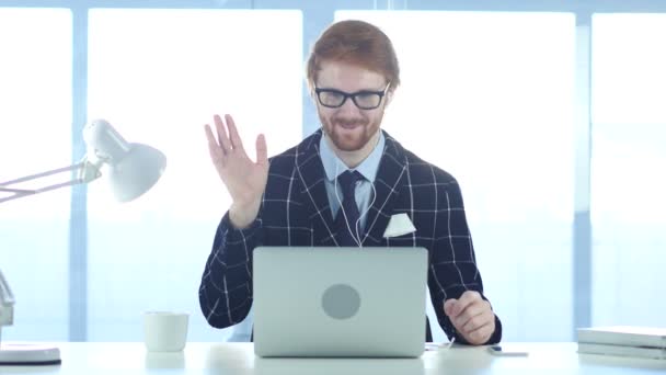 Κοκκινομάλλα επιχειρηματίας απασχολημένος σε απευθείας σύνδεση συνομιλία μέσω βίντεο στον φορητό υπολογιστή στην εργασία — Αρχείο Βίντεο