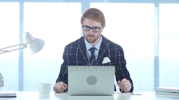 Рудий підприємець, який розслабляється і слухає музику на ноутбуці на роботі, закритий погляд — стокове відео