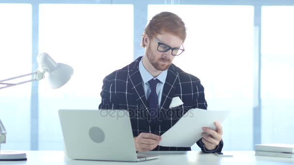 Redhead podnikatel čtení dokumentů v kanceláři, studie — Stock video