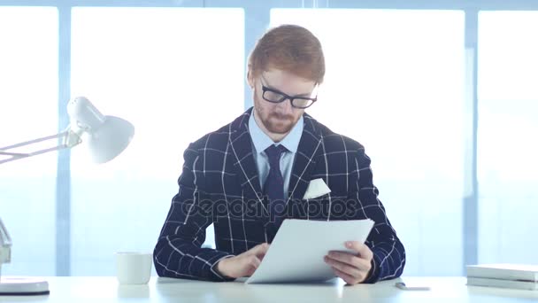 Homem leitura escritório Douments no trabalho, cabelos vermelhos — Vídeo de Stock