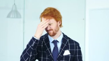 Baş ağrısı, üzgün gergin genç Redhead iş adamı