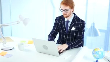 Kızıl saçlı işadamı kutluyor başarı dizüstü bilgisayar, heyecan çalışırken