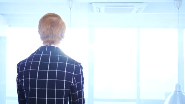 Rotschopf schaut durch klebrige Zettel, die im Büro an Glas befestigt sind — Stockvideo
