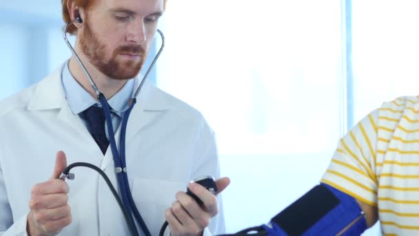 Läkare kontrollerar blodtryck av patient på klinik — Stockvideo