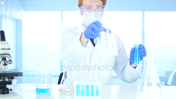 Ερευνητικός επιστήμονας ρίχνει χημικά σε ποτήρι ζέσεως για αντίδραση στο εργαστήριο, — Αρχείο Βίντεο