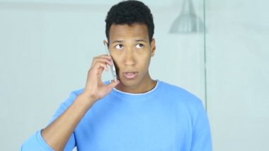 Afro-Amerikan adam ofiste smartphone cep telefonu ile konuşmak