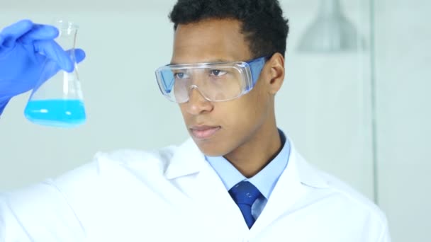 Tudós, orvos, látszó-on kék oldatot a lombikba-laboratóriumi — Stock videók